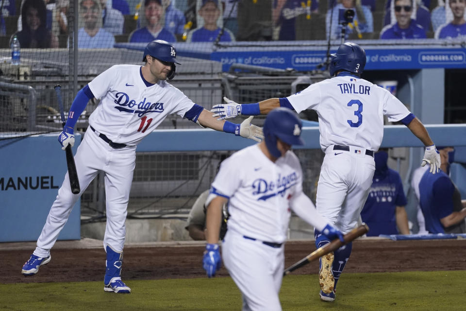 Los Angeles Dodgers' Chris Taylor, right, celebrates with A.J. Pollock after hitting a home run during the fourth inning of the team's baseball game against the Oakland Athletics on Tuesday, Sept. 22, 2020, in Los Angeles. (AP Photo/Ashley Landis)