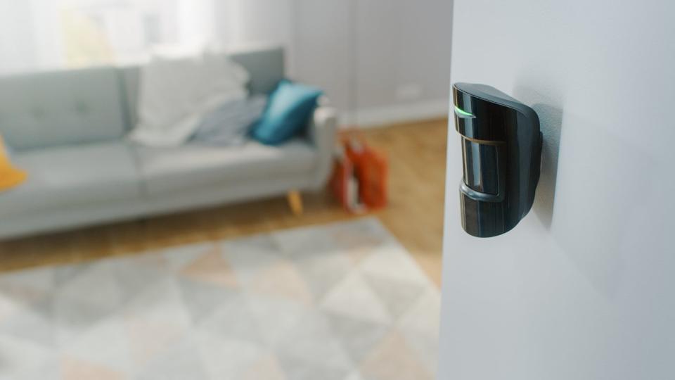 A close up of a black motion sensor light installed in a living room.