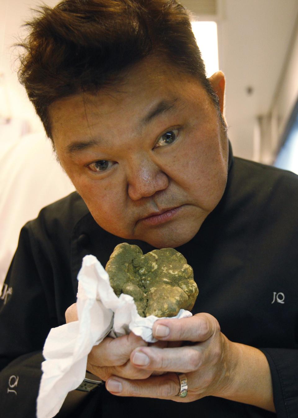 Singaporean chef Justin Quek smells a handful of truffles as he talks about his work in his kitchen at Sky On 57 restaurant at Marina Bay Sands in Singapore November 4, 2013. Modern fusion is the hallmark of Quek but tradition and technique are his unshakable foundation as he reinvents Asian favourites with French flavours and flair. Quek, principal chef at the tony Sky on 57 restaurant atop the Marina Bay Sands casino resort in Singapore, fell into his career by accident. Wanting to travel as a young man, he took a job on a merchant ship and ended up as a steward in the galley. Picture taken November 4, 2013. REUTERS/Edgar Su (SINGAPORE - Tags: SOCIETY FOOD)