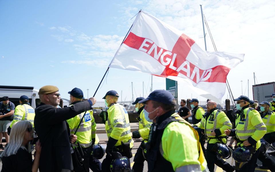 Anti-migrant protester tries to block a road during a demonstration in Dover against immigration - Andrew Matthews /PA