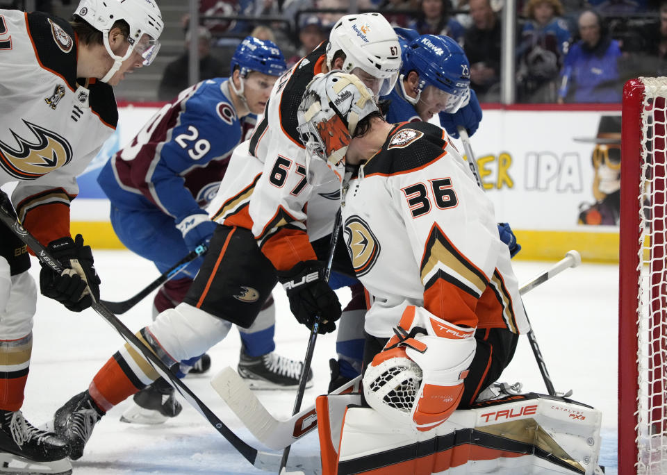 Anaheim Ducks goaltender John Gibson, front, allows a shot by Colorado Avalanche right wing Logan O'Connor, back right, to go in for a goal, as Ducks defenseman Tristan Luneau watches during the third period of an NHL hockey game Tuesday, Dec. 5, 2023, in Denver. (AP Photo/David Zalubowski)