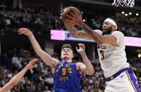 Los Angeles Lakers forward Anthony Davis (3) grabs a rebound against Denver Nuggets guard Christian Braun (0) during the second half in Game 1 of an NBA basketball first-round playoff series Saturday, April 20, 2024, in Denver. (AP Photo/Jack Dempsey)