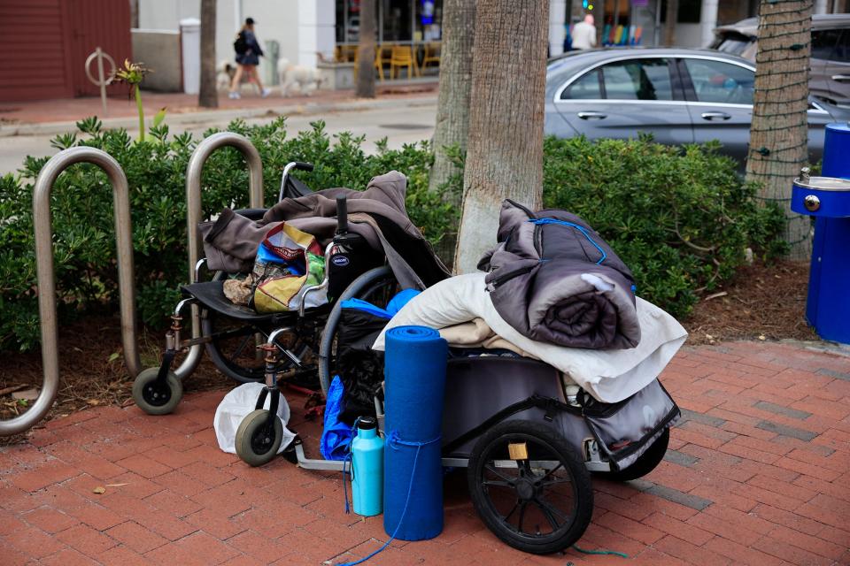 A cart containing blankets, pillows, supplies and a wheelchair sits unattended at Beaches Town Center Wednesday, Nov. 16, 2022 in Atlantic Beach. A proposed Atlantic Beach ordinance would prohibit sleeping or camping on city streets, parks and other public places. 