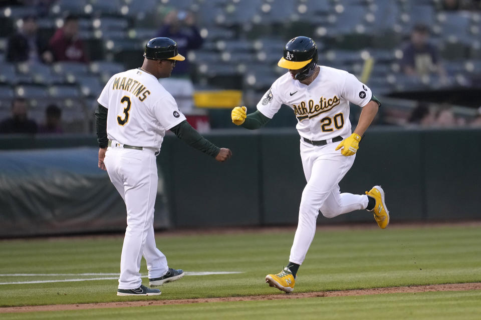 Oakland Athletics' Zack Gelof (20) is congratulated by third base coach Eric Martins (3) after hitting a home run against the Kansas City Royals during the third inning of a baseball game in Oakland, Calif., Monday, Aug. 21, 2023. (AP Photo/Jeff Chiu)