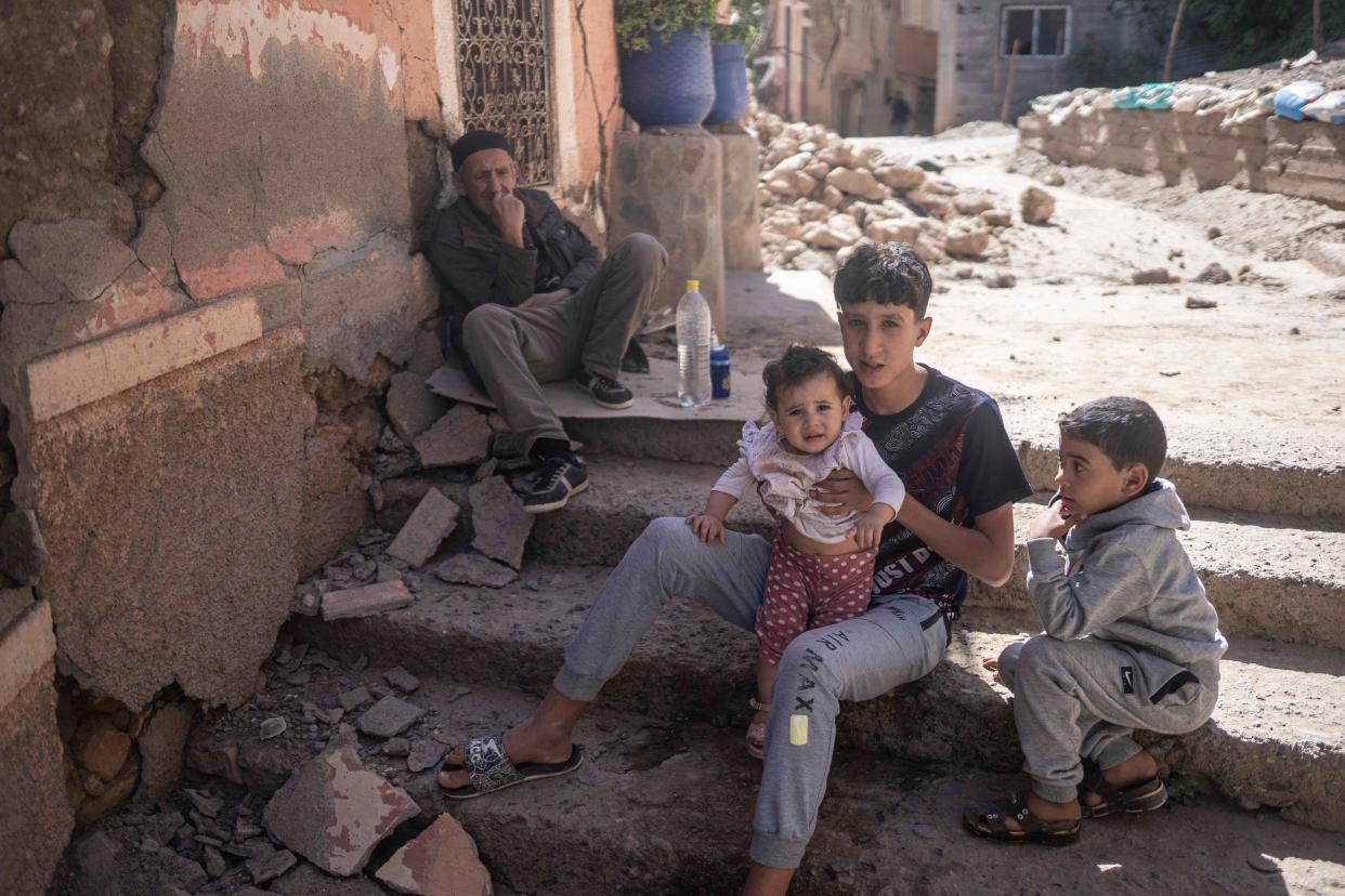 A family outside their destroyed home (AP)