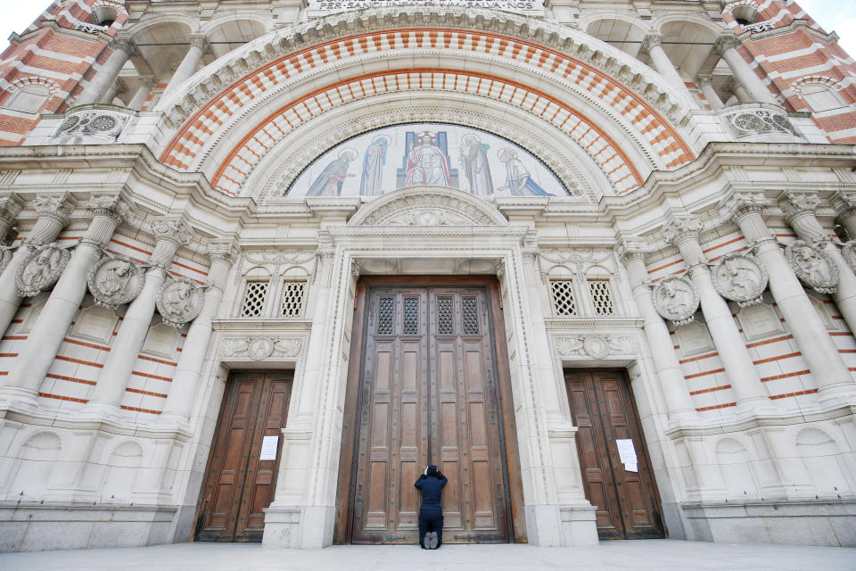 A woman prays at the closed doors of Westminster Cathedral ahead of the Easter morning mass, London, as the UK continues in lockdown to help curb the spread of the coronavirus. Churches across the country have been continuing to broadcast services digitally in the lead-up to Easter, with more than 1,000 livestreams taking place on a regular basis.