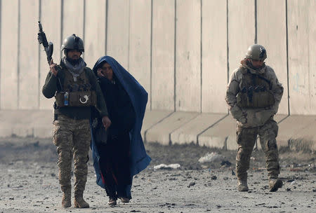 Afghan security forces escort a woman at the site of a car bomb blast in Kabul, Afghanistan January 15, 2019. REUTERS/Mohammad Ismail