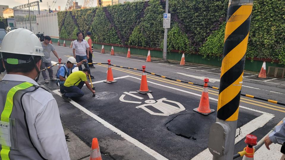 台北市南港路3段附近道路一處機車停等區內18日發生路面坍塌，現場出現一個深度、長度各約2公尺坑洞，經初步了解，疑是地下箱涵破洞漏水導致塌陷。（翻攝畫面／中央社）
