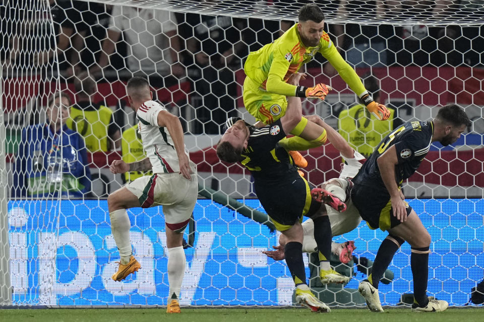 Scotland's goalkeeper Angus Gunn, up, collides with Hungary's Barnabas Varga, right, during a Group A match between Scotland and Hungary at the Euro 2024 soccer tournament in Stuttgart, Germany, Sunday, June 23, 2024. (AP Photo/Matthias Schrader)