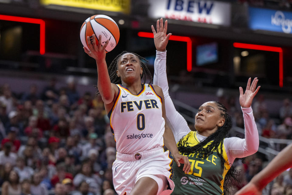 Indiana Fever guard Kelsey Mitchell (0) shoots ahead of Seattle Storm guard Victoria Vivians (35) during the first half of a WNBA basketball game, Thursday, May 30, 2024, in Indianapolis. (AP Photo/Doug McSchooler)