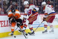 Philadelphia Flyers' Morgan Frost (48) battles for the puck with New Jersey Devils' Damon Severson (28) and Brendan Smith (2) during the second period of an NHL hockey game, Saturday, Dec. 3, 2022, in Philadelphia. (AP Photo/Matt Slocum)