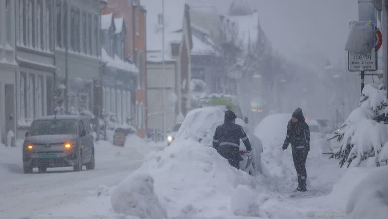 People attempt to clear the snow off a vehicle in Kristiansand, Norway, on Tuesday, Jan. 2, 2024. Finland and Sweden have recorded this winter’s cold records on Tuesday as a temperatures plummeted to over minus 40 degrees as a result of a cold spell prevailing in the Nordic region.