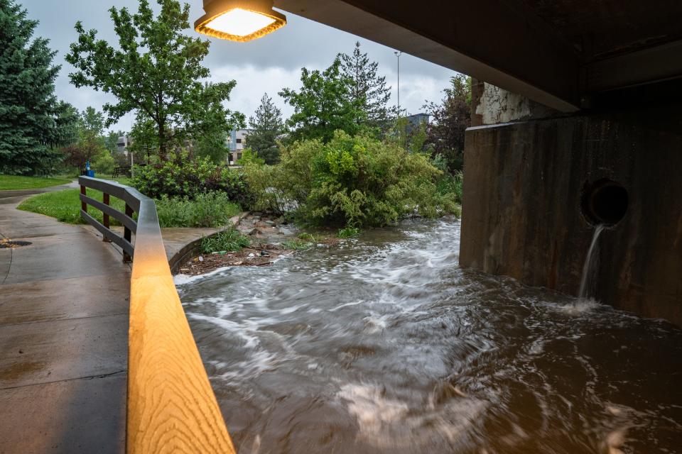 A swollen Spring Creek flows at Creekside Park during a heavy rainstorm on Sunday.