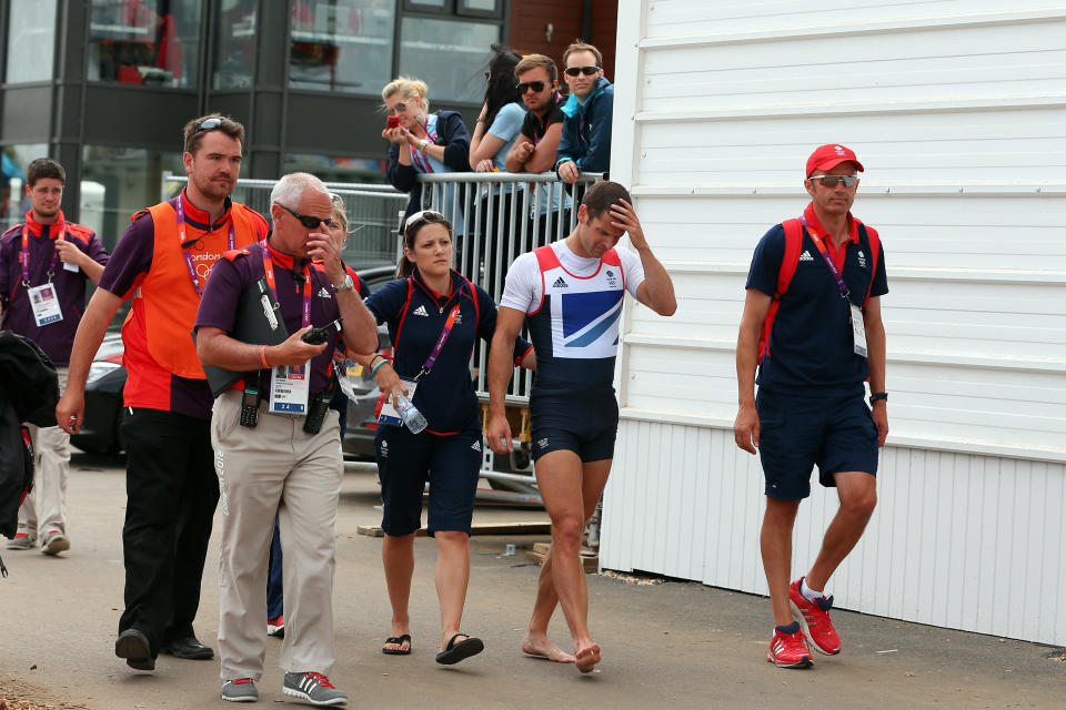 (C) Rower Chris Bartley of Great Britain is helped to the medal stand after having to be pulled out of his boat after winning the silver medal in the Lightweight Men's Four final on Day 6 of the London 2012 Olympic Games at Eton Dorney on August 2, 2012 in Windsor, England. (Photo by Ezra Shaw/Getty Images)