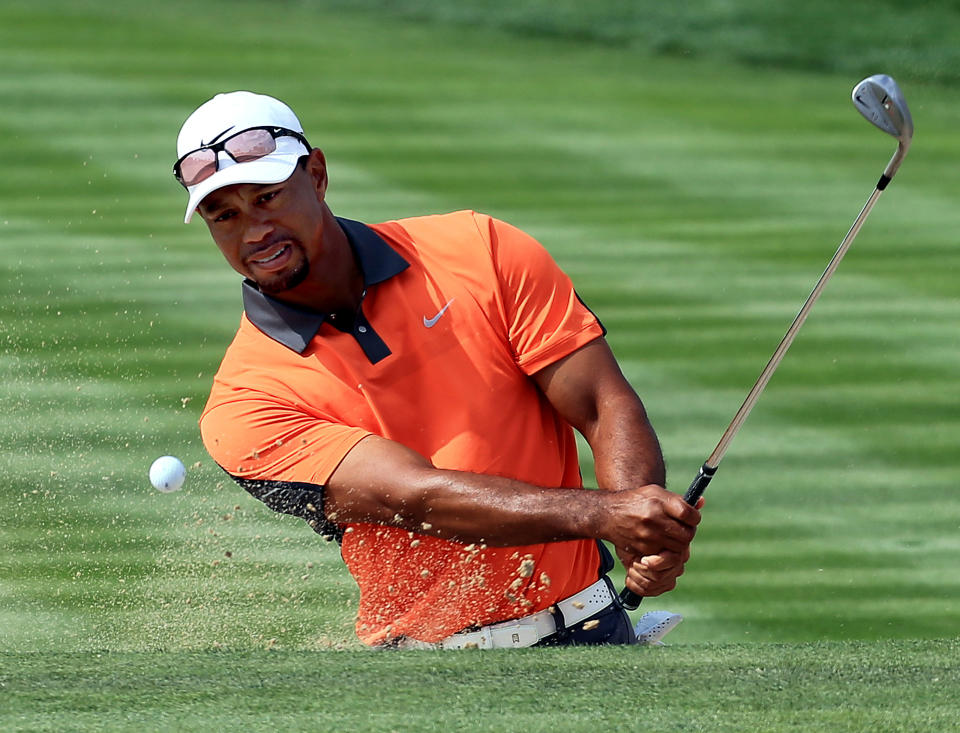 Tiger Woods of the U.S. hits a bunker shot on the 3rd hole during the third round of the Dubai Desert Classic golf tournament in Dubai, United Arab Emirates, Saturday, Feb. 1, 2014. (AP Photo)