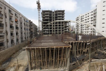 Laborers work on a building construction site in Karachi, Pakistan February 25, 2016. REUTERS/Akhtar Soomro