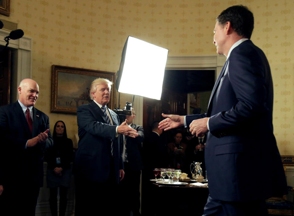 President Trump, with Secret Service Director Joseph Clancy, left, greets FBI Director James Comey at a reception on Jan. 22, 2017. (Photo: Joshua Roberts/Reuters)