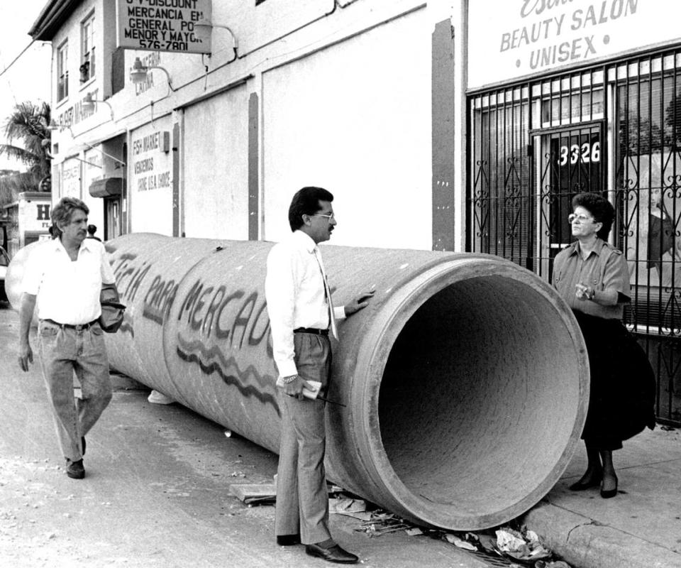 Eleno Alvarez, owner of Robert Super Market on Second Avenue between 33 and 34th Streets, approaches Fred Santiago and Mrs. Elena Alvarez as they talk over the construction problems plaguing their neighborhood. Donna E. Natale/Miami Herald File/1991