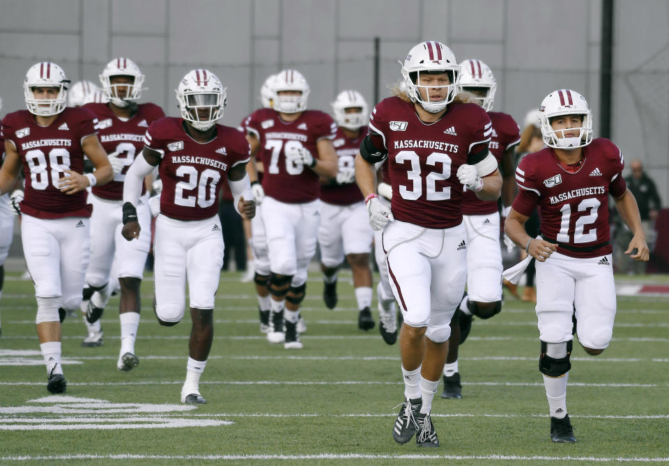 FILE - In this Oct. 26, 2019, file photo Massachusetts players enter the field for an NCAA college football game against Connecticut, in Amherst, Mass. Massachusetts is the latest school from the Football Bowl Subdivision, college football’s highest level, to cancel its fall season. (AP Photo/Jessica Hill, File)