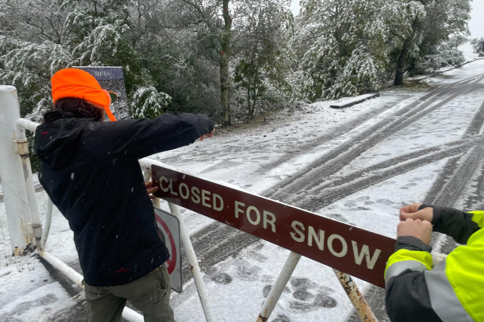 A parks worker puts up a closed sign at the entrance to Mount Tamalpais State Park in Mill Valley, Calif., Friday Feb. 24, 2023. California and other parts of the West are facing heavy snow and rain from the latest winter storm to pound the United States. The National Weather Service has issued blizzard warnings for the Sierra Nevada and Southern California mountains. (AP Photo/Haven Daley)