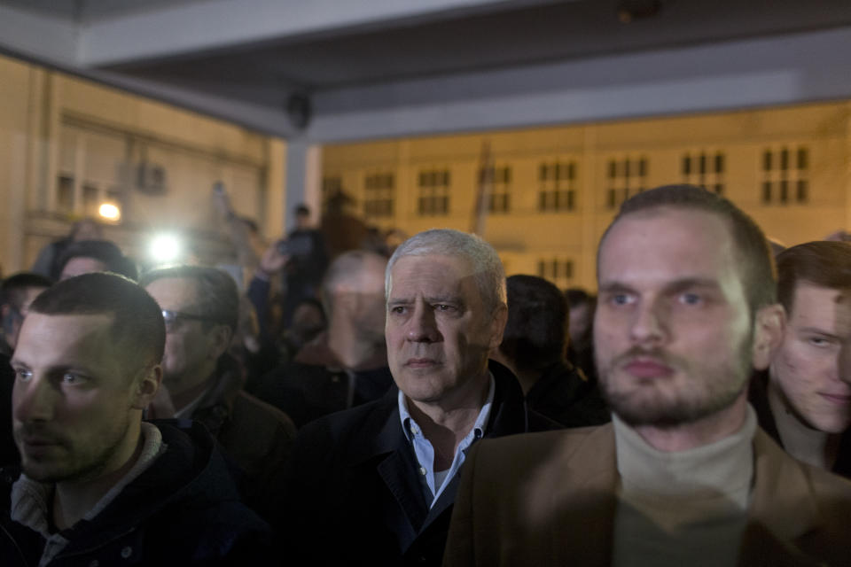 Boris Tadic, center, former Serbian president, stands with other demonstrators at the state-run TV headquarters in Belgrade, Serbia, Saturday, March 16, 2019. Demonstrators protesting the autocratic rule of Serbian President Aleksandar Vucic burst into state-run TV headquarters in Belgrade on Saturday to denounce a broadcaster whose reporting they consider highly biased. (AP Photo/Marko Drobnjakovic)