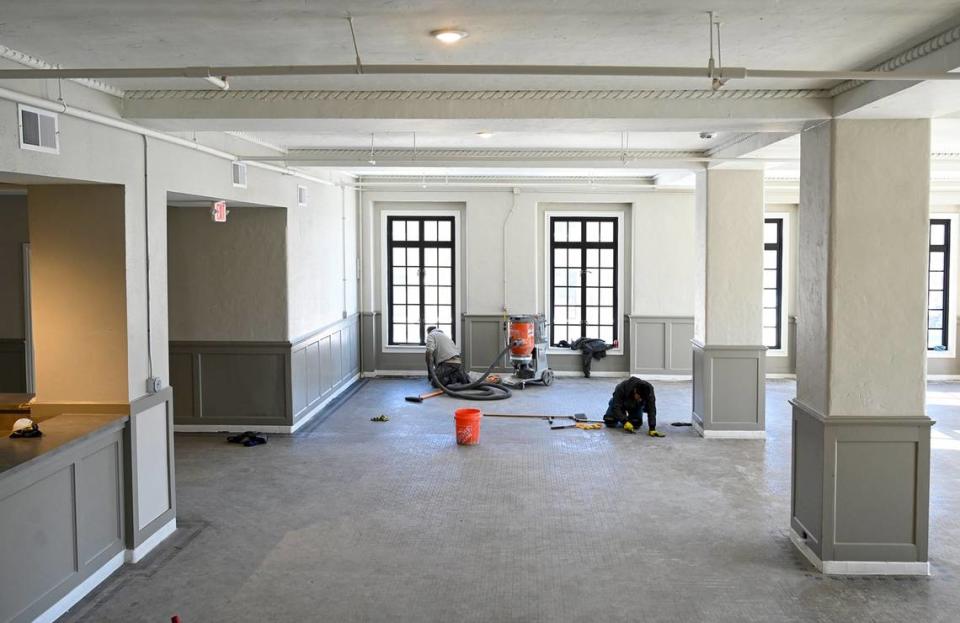 Workers remove residue and remnants of old carpeting from the floors in the lobby and main entrance area of the old YMCA building.