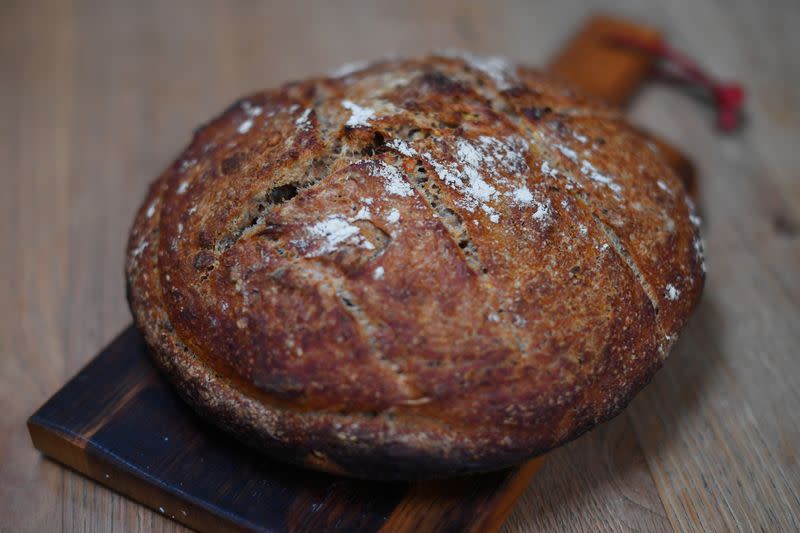 A first-attempt at a homemade seeded sourdough loaf is seen on a kitchen table in London