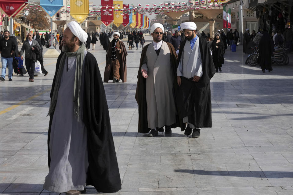 Clerics walk in front of the Fatima Masumeh Shrine at the city of Qom, some 80 miles (125 kilometers) south of the capital Tehran, Iran, Tuesday, Feb. 7, 2023. (AP Photo/Vahid Salemi)