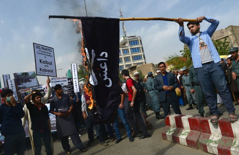 Afghan Solidarity members burn an Islamic State flag during a rally against the IS group in Kabul on October 12, 2014
