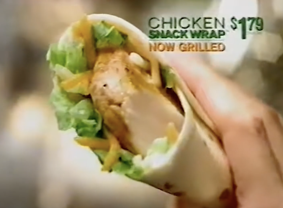 A hand holds a chicken snack wrap with lettuce, cheese, and grilled chicken. Text overlay reads, "Chicken Snack Wrap $1.79 Now Grilled."