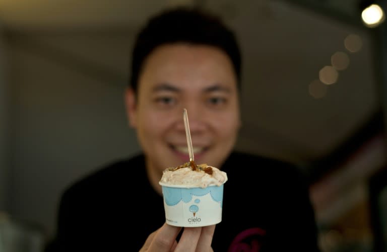 Ong Kee Win, owner of Cielo Dolci cafe, poses with a cup of nasi lemak ice cream at his cafe in Kuala Lumpur