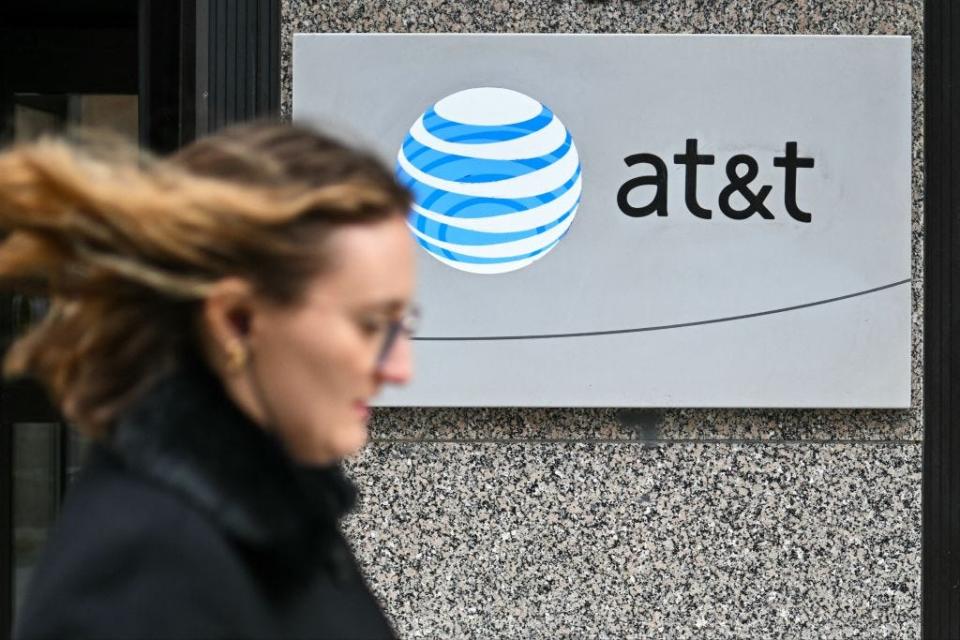 A woman walks past signage for AT&T in Washington, DC, on February 22, 2024.