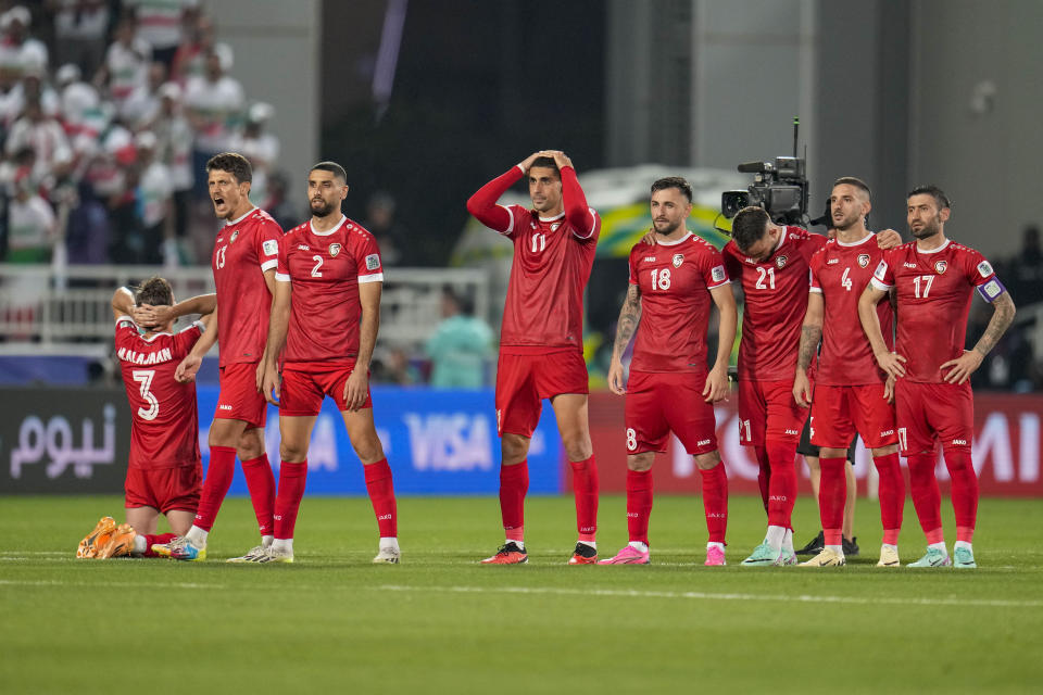 Syria players stand on the pitch during the penalty shootout during the Asian Cup Round of 16 soccer match between Iran and Syria, at Abdullah Bin Khalifa Stadium in Doha, Qatar, Wednesday, Jan. 31, 2024. (AP Photo/Aijaz Rahi)