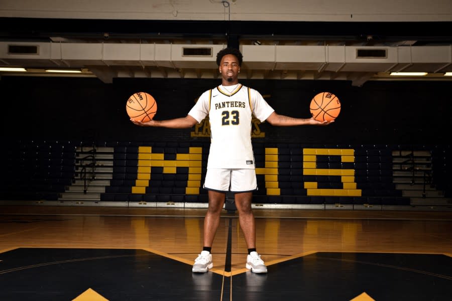 Murphy High School Panther holds two basketballs in both hands. 