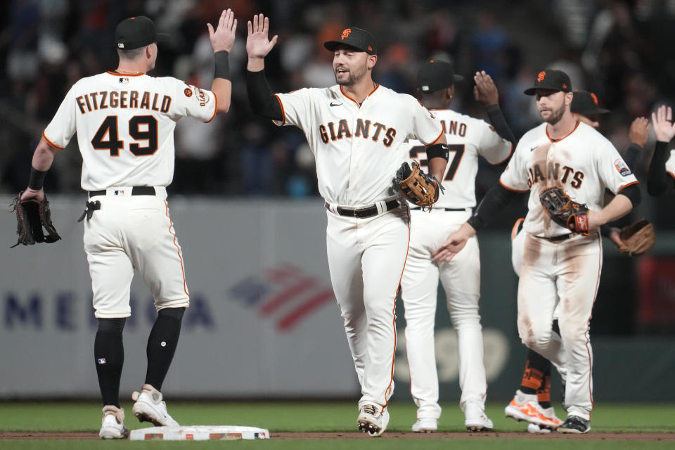 San Francisco Giants' Tyler Fitzgerald (49) celebrates with Michael Conforto, middle, and teammates after the Giants defeated the San Diego Padres in a baseball game in San Francisco, Monday, Sept. 25, 2023. (AP Photo/Jeff Chiu)