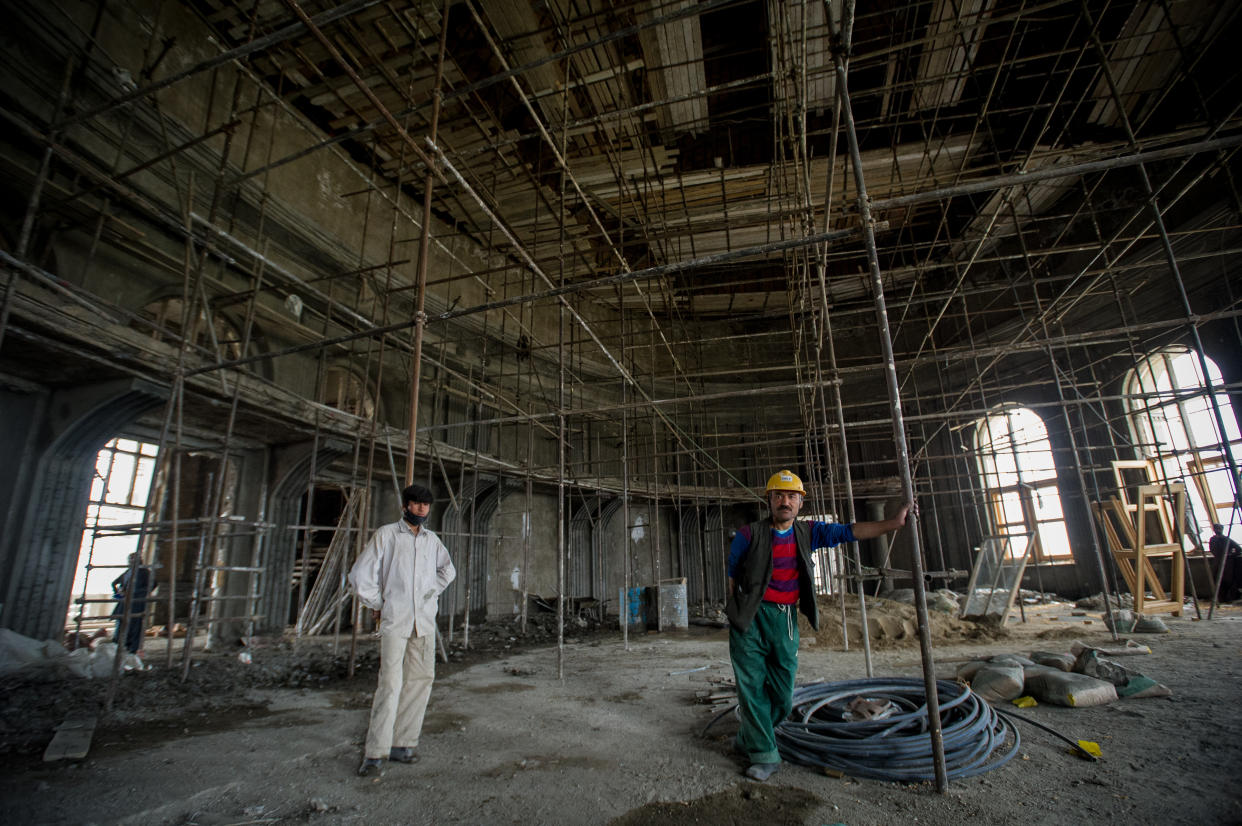 Men stand in a large chamber as Afghan workers rebuild the iconic Darulaman Palace, after decades in which its ruins were a reminder of constant conflict, on May 21, 2019, in Kabul, Afghanistan. (Scott Peterson/Getty Images)