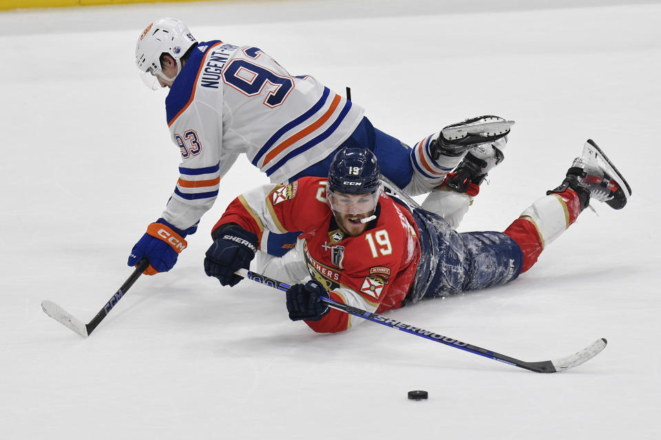 Florida Panthers left wing Matthew Tkachuk (19) takes control of the puck as Edmonton Oilers center Ryan Nugent-Hopkins (93) defends during the third period of Game 2 of the NHL hockey Stanley Cup Finals, Monday, June 10, 2024, in Sunrise, Fla. (AP Photo/Michael Laughlin)