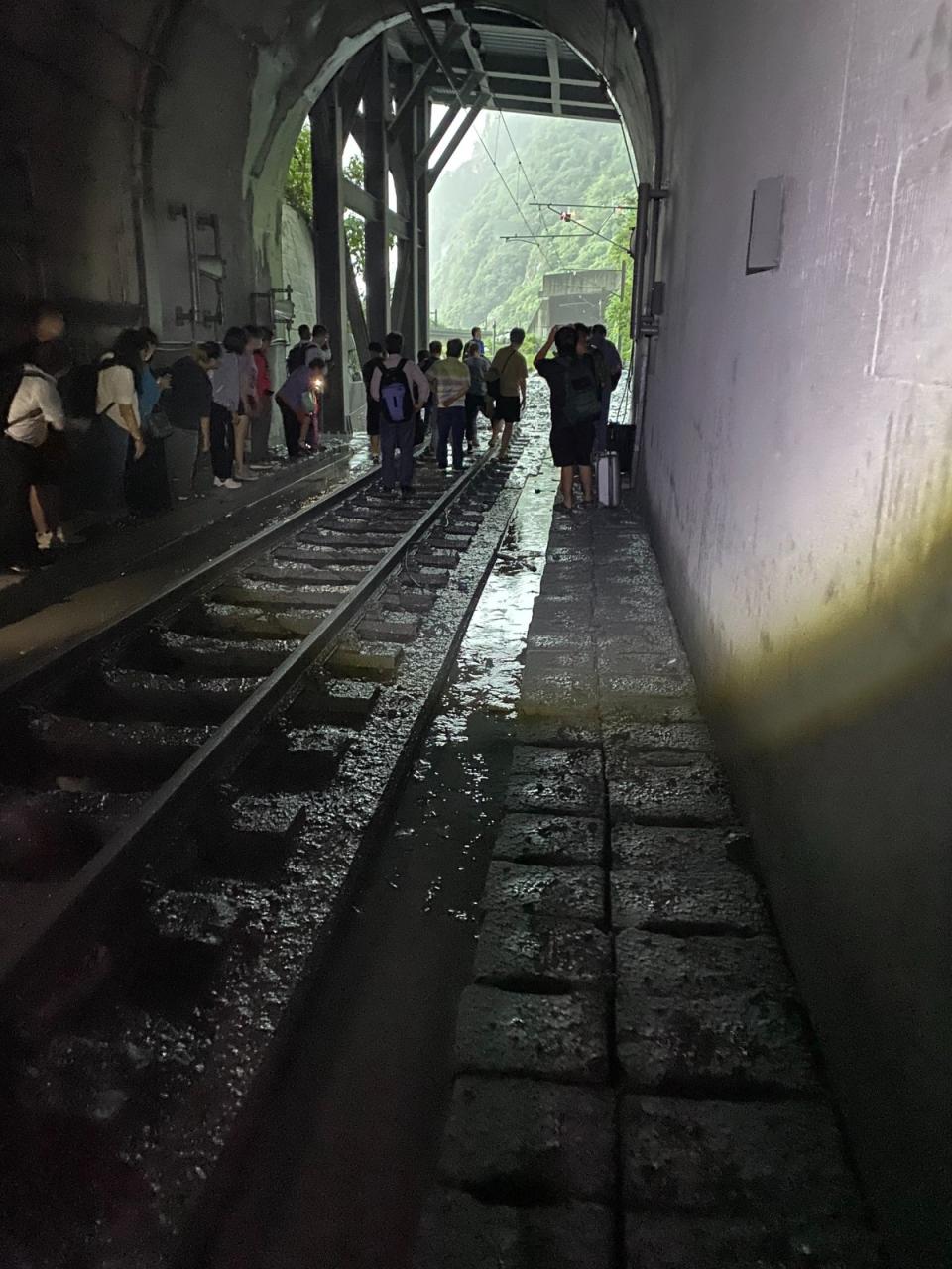 台鐵自強號第229次北上列車今（6/21）清水隧道受到土石流衝擊出軌，乘客下車步行搭接駁車。讀者提供