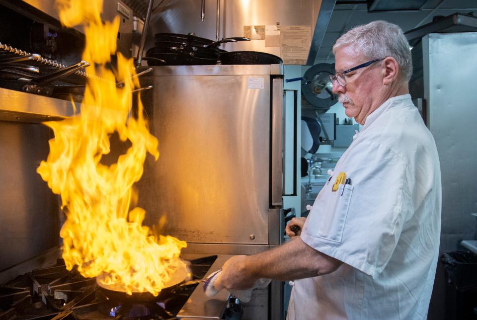 Chef Gregg McCarthy prepares an order of shrimp and grits at the Grand Marlin in Pensacola Beach on Thursday, May 19, 2022.  McCarthy will be one of four renowned chefs who will be participating in the G&G Seafood Rodeo.