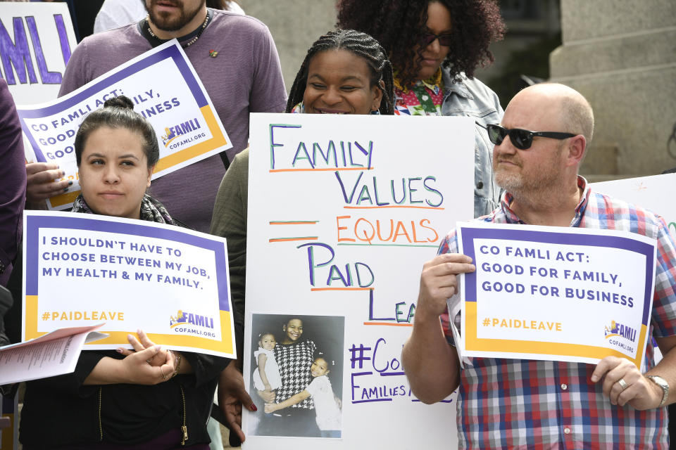 Jasmine White, middle, holds up a sign alongside supporters of Senate bill 19-188 during a rally on the west steps of the State Capitol on April 9, 2019, in Denver, Colorado. During two pregnancies, White, as a single parent and sole provider for her family, had to work two jobs that didn't offer any leave.  (Photo: Helen H. Richardson/MediaNews Group/The Denver Post via Getty Images)