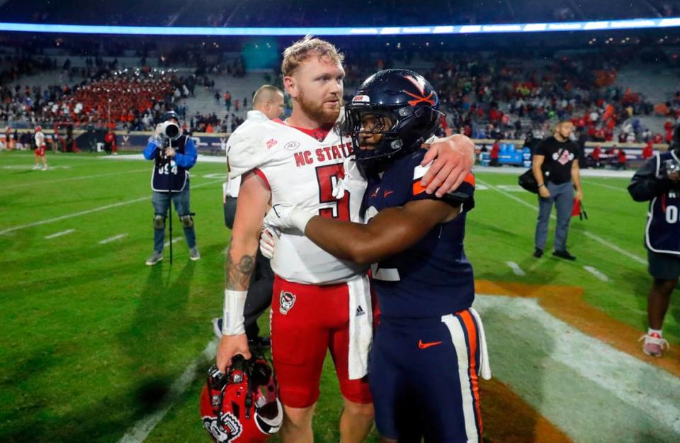 N.C. State quarterback Brennan Armstrong (5) talks with Virginia running back Perris Jones (2) after the Wolfpack’s 24-21 victory over Virginia at Scott Stadium in Charlottesville, Va., Friday, Sept. 22, 2023.