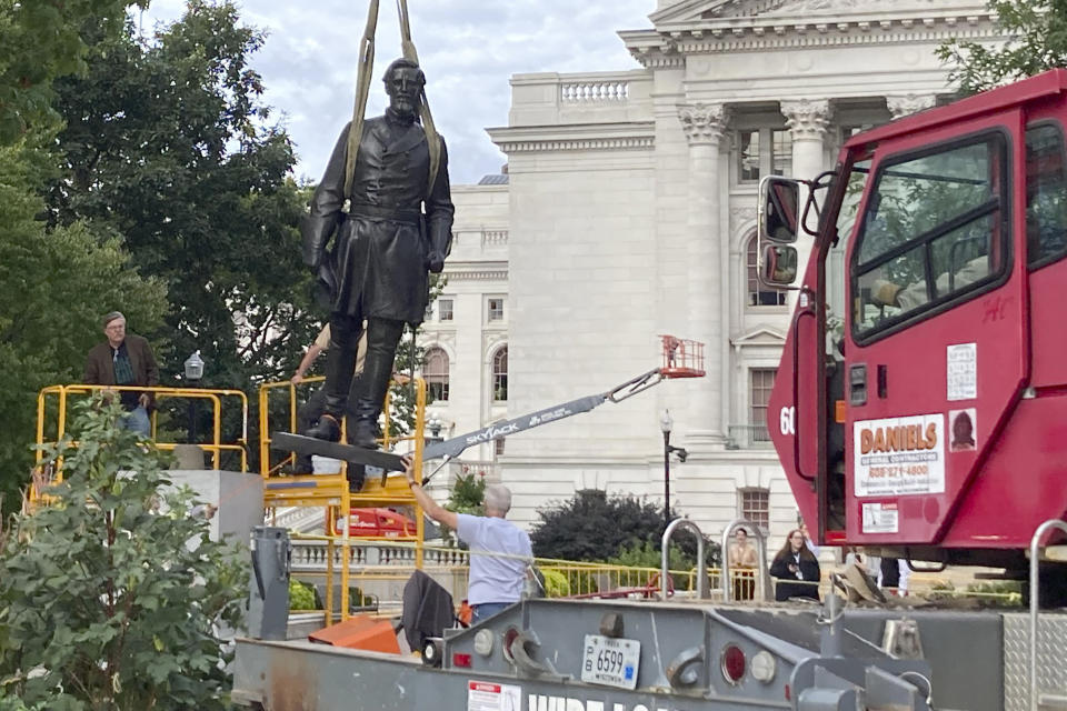 Workers reinstall a statue of Wisconsin abolitionist Col. Hans Christian Heg outside the state Capitol in Madison, Wis., on Tuesday, Sept. 21, 2021. Protesters tore the 9-foot-6-inch statue down and ripped its head off in June 2020 during a demonstration over George Floyd's death in Minneapolis. (AP Photo/Todd Richmond)