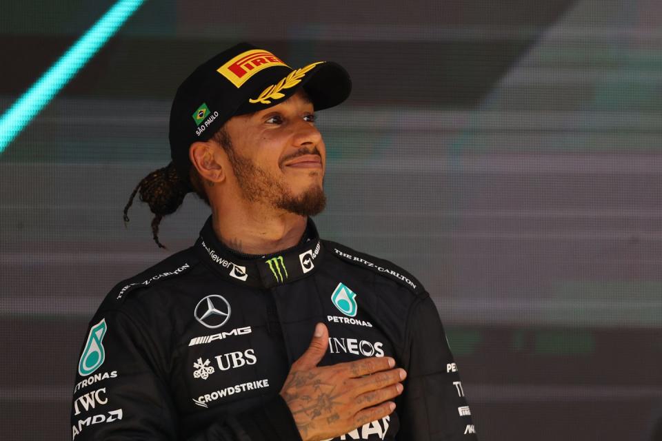 formula 1 driver lewis hamilton smiles and places his hand on his heart during the celebrations after a grand prix