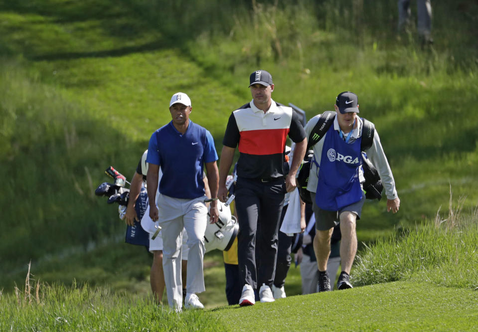 Tiger Woods, left, and Brooks Koepka walk to the 14th fairway during the first round of the PGA Championship golf tournament, Thursday, May 16, 2019, at Bethpage Black in Farmingdale, N.Y. (AP Photo/Julio Cortez)