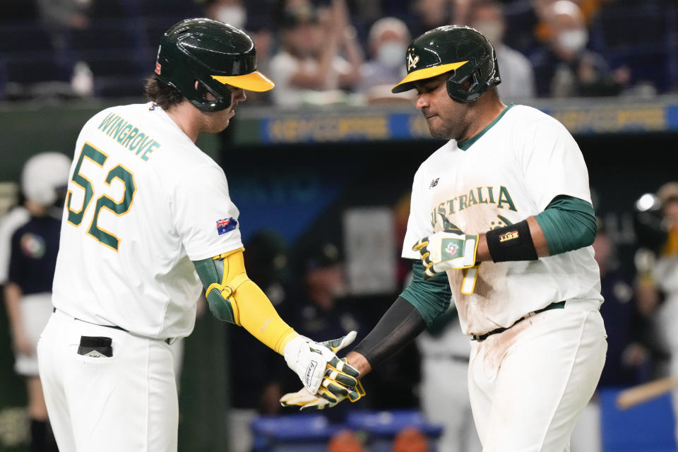 Darryl George, right, of Australia is congratulated by teammate Rixon Wingrove after completing a home run during their Pool B game against Chinaat the World Baseball Classic at the Tokyo Dome, Japan, Saturday, March 11, 2023. (AP Photo/Eugene Hoshiko)