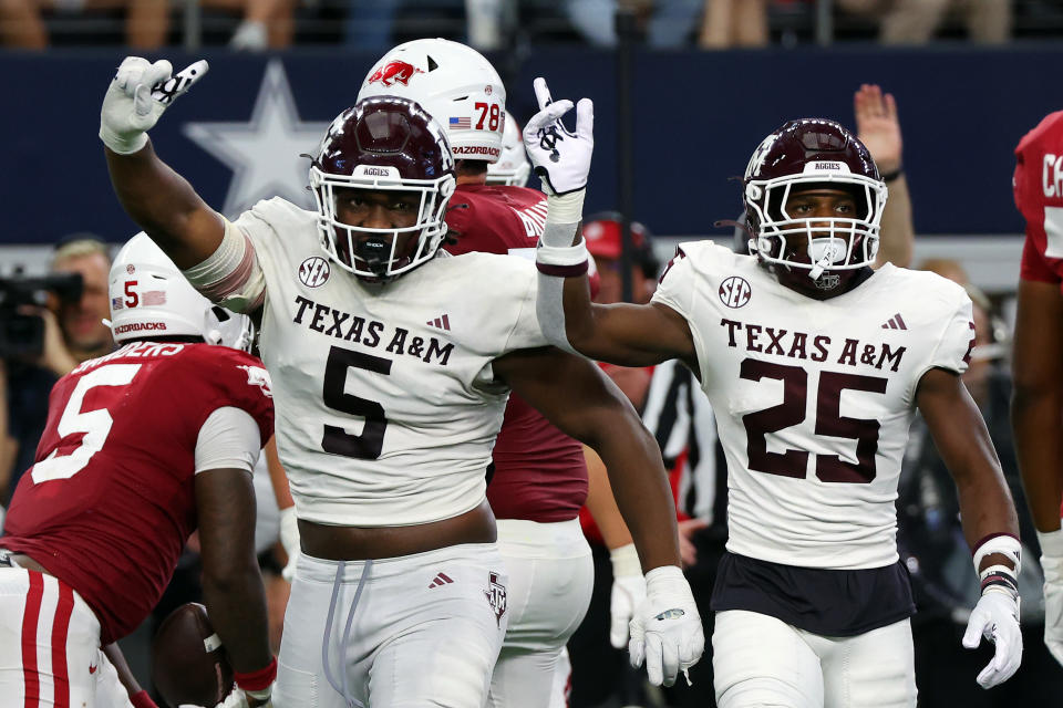ARLINGTON, TEXAS - SEPTEMBER 30: Defensive lineman Shemar Turner #5 and defensive back Dalton Brooks #25 of the Texas A&M Aggies gesture after stopping a run by running back Raheim Sanders #5 of the Arkansas Razorbacks in the fourth quarter of the Southwest Classic at AT&T Stadium on September 30, 2023 in Arlington, Texas. (Photo by Richard Rodriguez/Getty Images)