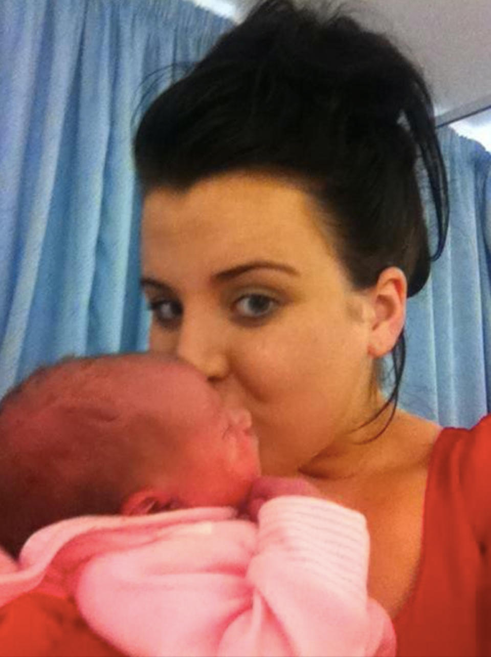 Nicole Moore kisses her newborn daughter Tilly in the hospital after giving birth