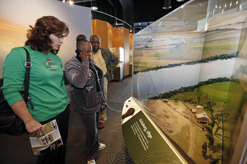 In this Dec. 18, 2012 photograph, Mississippi Association of Educators staff Beverly Brahan, left, watches while Sheila Washington, center, listens to a "farmer" describe what life was like on a Vicksburg farm in 1890 at the Lower Mississippi River Museum in Vicksburg, Miss. The interactive video is one of several at the museum provides visitors with a extensive look at life surrounding the Mississippi River through several centuries by way of its interactive and static displays. Visitors also have the opportunity to tour the Motor Vessel Mississippi IV exhibit and see how crews worked and lived on the towboats used by the U.S. Army Corps of Engineers. (AP Photo/Rogelio V. Solis)