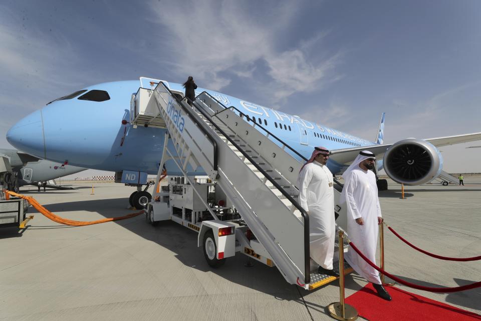 People visit an Ethihad plane during the opening day of Dubai Airshow in Dubai, United Arab Emirates, Sunday, Nov. 17, 2019. The biennial Dubai Airshow has opened as major Gulf airlines reign back big-ticket purchases after a staggering $140 billion in new orders were announced at the 2013 show before global oil prices collapsed.(AP Photo/Kamran Jebreili)