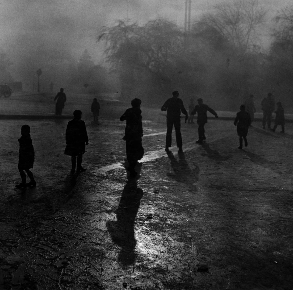 Fog and ice on Hampstead Heath. Boys sliding on the ice in the fog at Hampstead Heath ponds. Although the weather was wintry and the fog was thick, the usual crowd of small boys just naturally gravitated to the ponds on Hampstead Heath when the word went out that the ice was thick enough to stand on. There despite the wintry conditions, 30 odd small boys with the usual supply of small dogs had a wonderful time sliding on the ice, 7th December 1952. (Photo by Phil Dye/Daily Mirror/Mirrorpix/Getty Images)